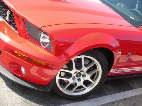 1998 Ford Crown Victoria - Red Ford Mustang Shelby GT500 with distinctive wheels and side stripes.