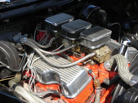 1998 Ford Crown Victoria - Close-up of a modified V8 engine triple carburetors and chrome accents.