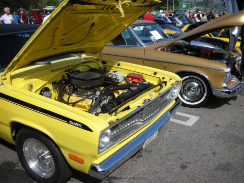 1998 Ford Crown Victoria - Two classic cars with hoods open are parked side-by-side at an outdoor event.