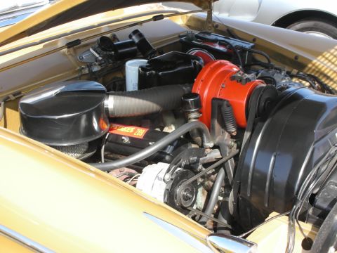 1998 Ford Crown Victoria - The engine bay of a gold-colored car is visible, showing various engine components and a label on the engine block.