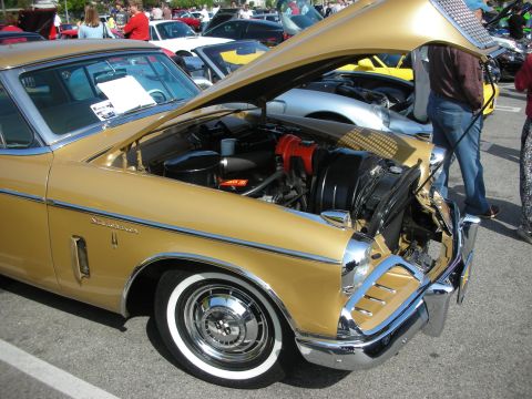 1998 Ford Crown Victoria - A gold classic car is displayed with its hood open, revealing the engine compartment at an outdoor car meet.