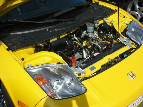 1998 Ford Crown Victoria - The engine bay of a yellow sports car is open, revealing its mechanical components.