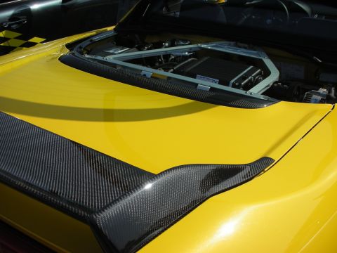 1998 Ford Crown Victoria - A close-up view of a yellow sports car's engine bay, carbon fiber accents and a glimpse of another vehicle.