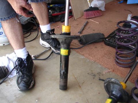 1992 Ford Taurus - A car strut assembly is shown on the ground, with tools and springs scattered around.