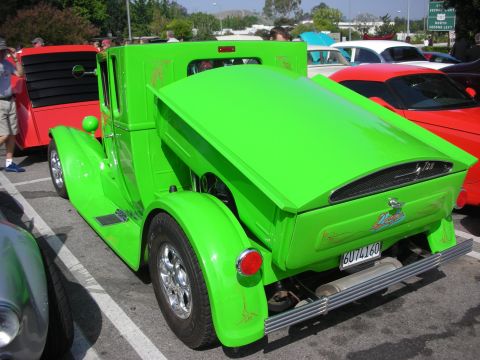 1998 Ford Crown Victoria - A bright green custom pickup truck is parked at an outdoor car show next to other vehicles.