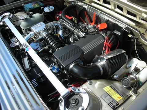 1998 Ford Crown Victoria - A detailed view of a BMW engine bay, a performance strut bar and custom air intake system.