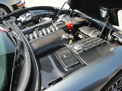 1998 Ford Crown Victoria - Engine bay details with carbon fiber accents, partially visible in a parking lot with another vehicle.