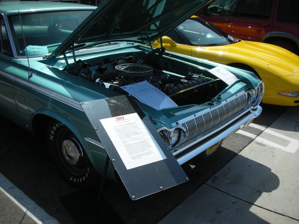 Teal 1965 Dodge Polara with hood open, parked next to a yellow Corvette