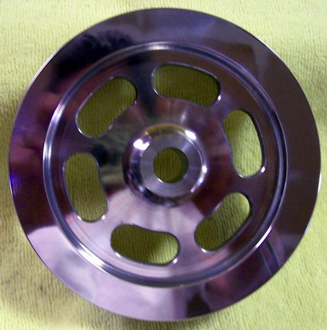 2002 Ford Mustang - Polished metal pulley with oval cutouts, likely an aftermarket part. Supermotors.net logo visible.