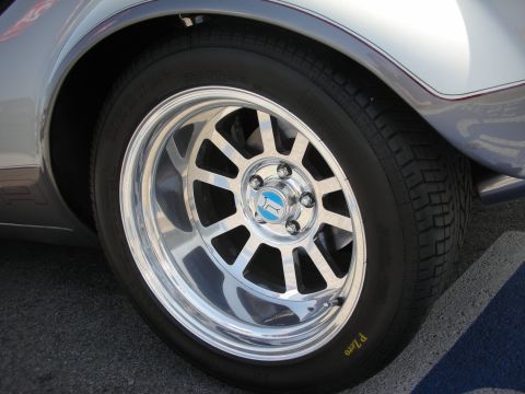 1998 Ford Crown Victoria - A close-up view of a chrome wheel with a distinctive blue and white center cap and a Pirelli P Zero tire.