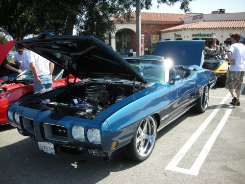 1998 Ford Crown Victoria - Blue 1970 Pontiac GTO convertible on display at a car meet, engine exposed.