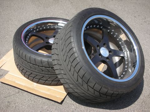 1998 Ford Crown Victoria - Aftermarket wheels and tires are displayed on cardboard, resting on asphalt.