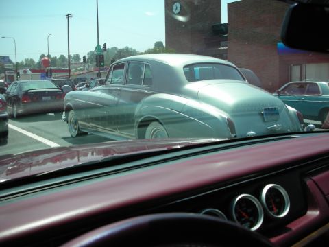 1998 Ford Crown Victoria - A classic light blue sedan is seen from behind while stopped in traffic, with other vehicles visible.