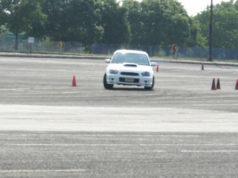 2001 Mercury Grand Marquis - A white Subaru WRX STI navigates a cone course, likely during a timed event.