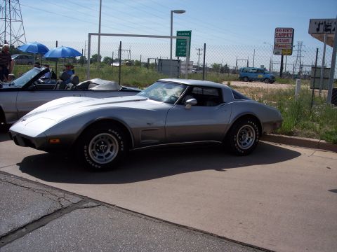 1972 Ford Ranchero - A silver Chevrolet Corvette is parked on a sunny day, with another convertible and a blue van visible in the background.