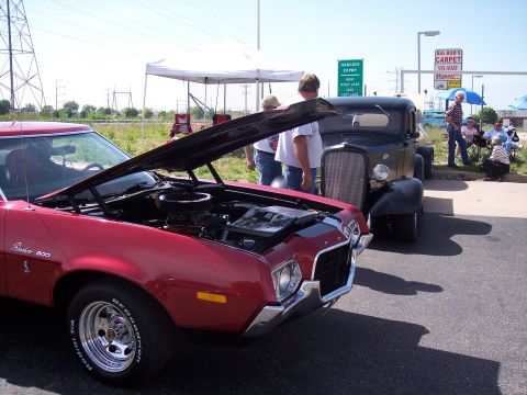 1972 Ford Ranchero - A red Ford Ranchero 500 from the early 1970s is displayed with its hood up, parked next to another classic vehicle.