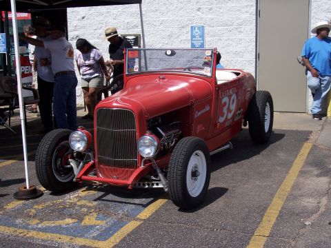1972 Ford Ranchero - A red hot rod with racing decals and the number 39 is parked outside a building.