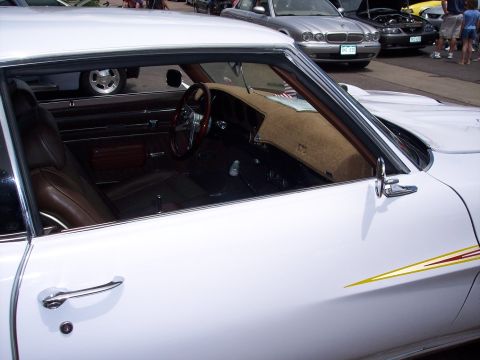 1972 Ford Ranchero - Interior view of a white 1972 Ford Ranchero, its brown upholstery and wood-rimmed steering wheel.