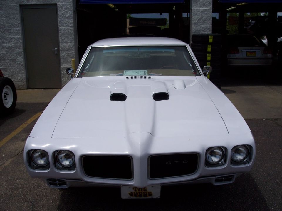 White 1970 Pontiac GTO with a prominent hood scoop and GTO badging on the grille