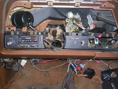 1975 Ford Ranchero - The dashboard of a vehicle is shown with many wires and electrical components exposed.
