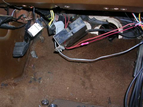 1975 Ford Ranchero - The interior of a vehicle shows a complex wiring harness and fuse box near the pedals.