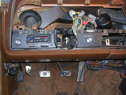 1975 Ford Ranchero - The dashboard of a vehicle shows exposed wiring and the radio unit, indicating a possible repair or modification.