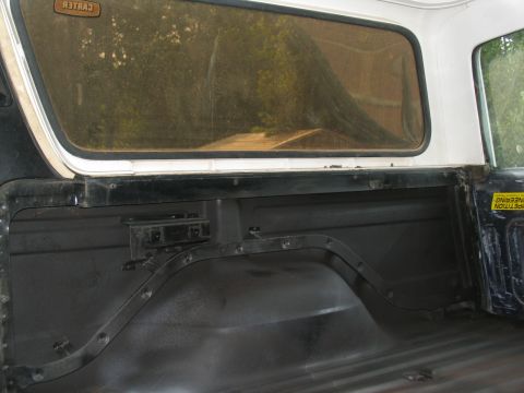 1978 Ford Bronco - Close-up of the interior of a truck bed, focusing on the wheel well area and side panel.