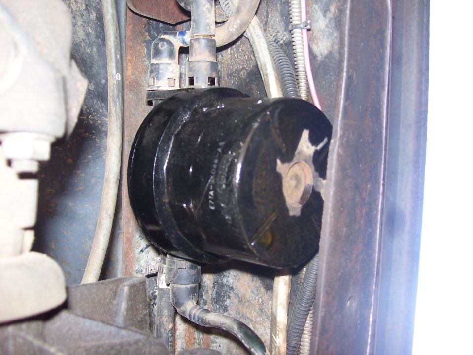 Black cylindrical part with hoses and text E7TA-2C044-AA