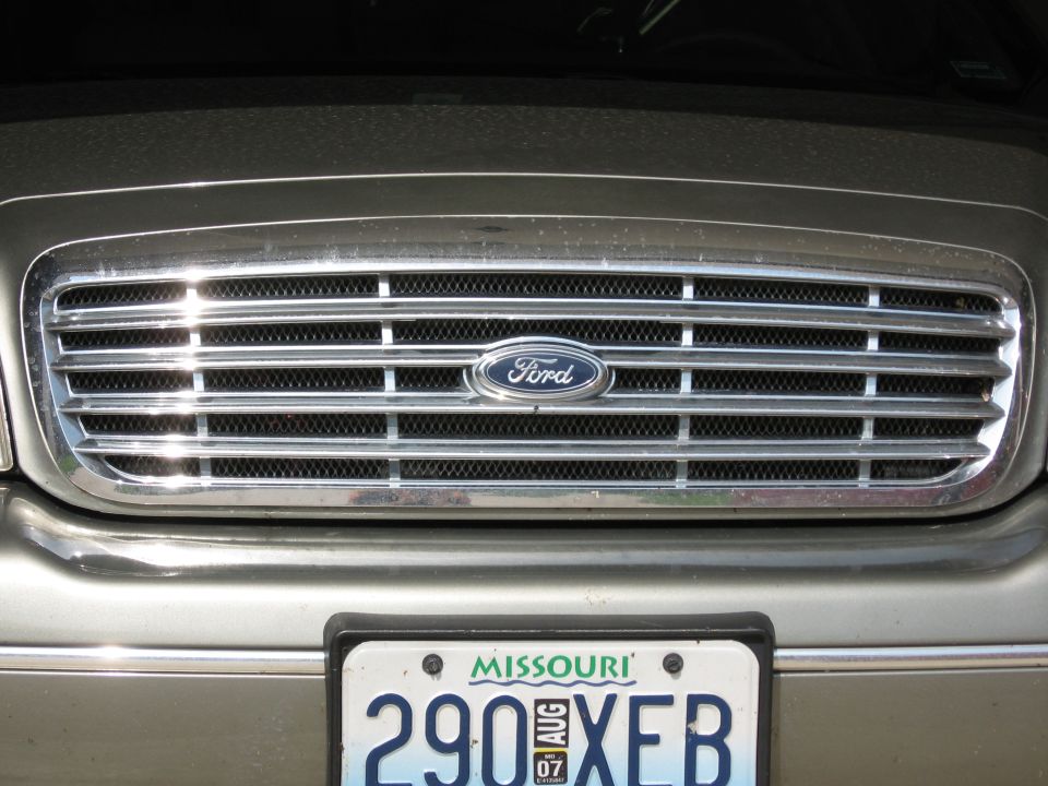 Chrome Ford grille and oval badge above a Missouri license plate on a gold sedan