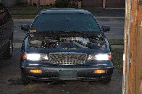 1985 Mercury Grand Marquis - Dark blue Mercury Grand Marquis, hood open, parked in a driveway with garage door visible.