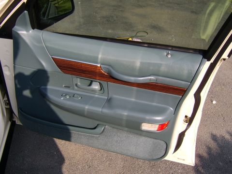 1996 Mercury Grand Marquis - Interior door panel of a 1996 Mercury Grand Marquis, showing wood trim and controls.