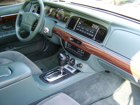 1996 Mercury Grand Marquis - The interior of a 1996 Mercury Grand Marquis features wood trim, a digital clock, and a clean dashboard.