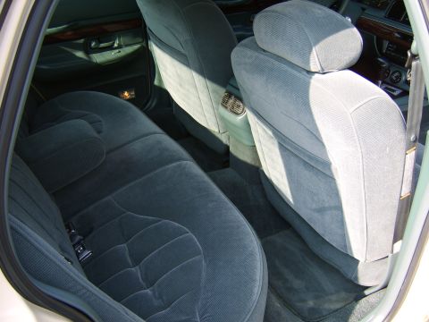 1996 Mercury Grand Marquis - The interior of a 1996 Mercury Grand Marquis features gray velour upholstery and wood accents on the door panels.