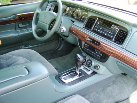 1996 Mercury Grand Marquis - The interior of a car shows a dashboard with wood trim and an automatic transmission shifter.