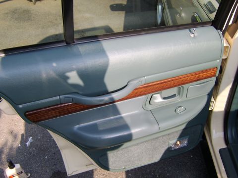 1996 Mercury Grand Marquis - Interior door panel of a 1996 Mercury Grand Marquis, showing wood trim and gray upholstery.