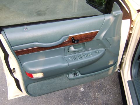 1996 Mercury Grand Marquis - Interior door panel detail of a 1996 Mercury Grand Marquis, showing wood trim and controls.