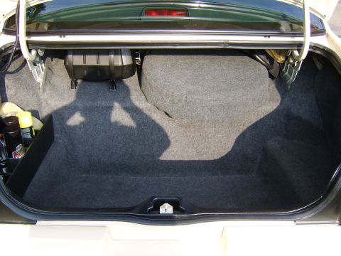 1996 Mercury Grand Marquis - The trunk of a car, showing the spare tire compartment and carpeted interior.