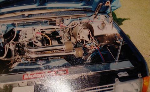 1999 Ford Crown Victoria - Engine bay view showing chrome exhaust headers and wiring. The year is not discernible from the image.