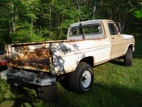 1967 Ford F-250 - This 1967 Ford F-250 pickup truck is seen from the rear 3/4 angle, parked outdoors on a grassy area.
