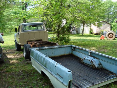 1967 Ford F-250 - Two Ford F-250 pickup truck beds are visible, one attached to a cab, in a grassy yard.