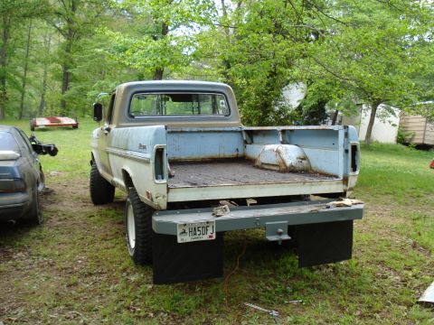 1967 Ford F-250 - This Ford pickup truck, likely from the early 1970s, is parked outdoors with a trailer and another vehicle nearby.