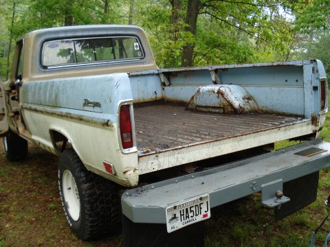1967 Ford F-250 - This 1967 Ford F-250 pickup truck shows significant wear and tear, with a two-tone paint scheme and a rusty bed.