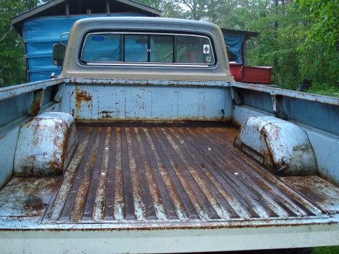 1967 Ford F-250 - The bed of a 1967 Ford F-250 pickup truck, showing significant rust on the floor and wheel wells.