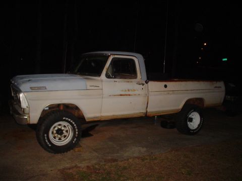 1967 Ford F-250 - This older model Ford truck shows significant rust along its body panels and bed.