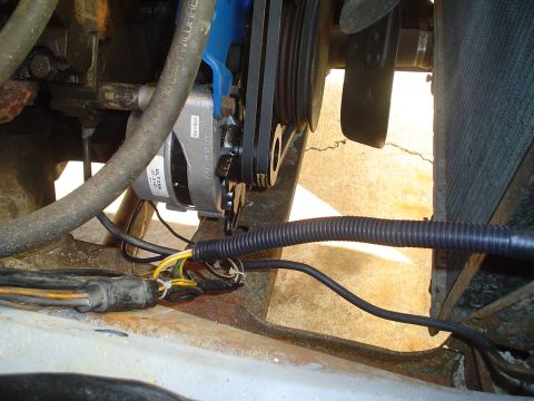 1967 Ford F-250 - Close-up view of engine wiring and alternator, showing various hoses and electrical connections.