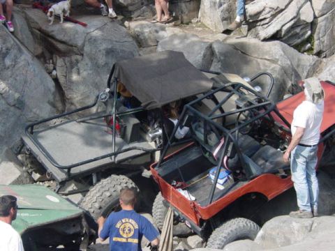 1986 Ford Bronco - Off-road vehicles struggle on a challenging rocky obstacle course during an event.