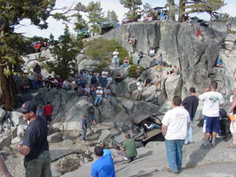 1986 Ford Bronco - Spectators gather to watch off-road vehicles traverse a challenging rocky incline.
