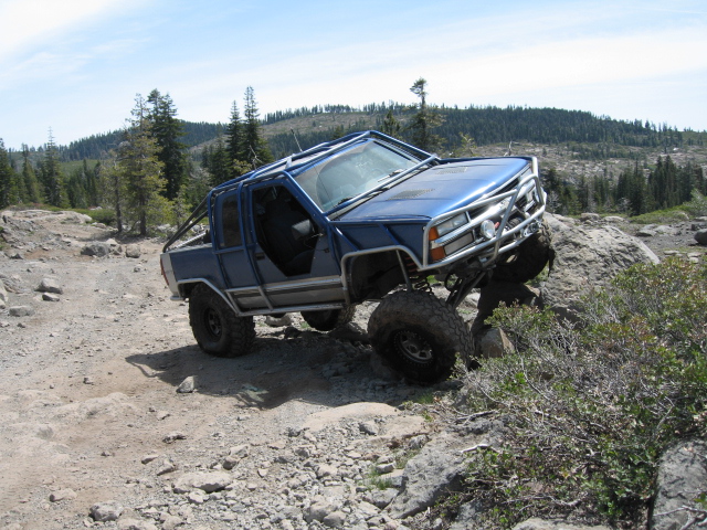 Blue 1997 Chevrolet C/K Pickup off-roading on rocky terrain
