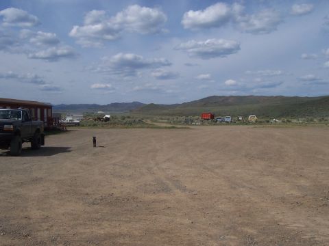 1994 Ford F-150 - 1994 Ford F-150 parked in a rural lot with a dog and several other vehicles in the distance.