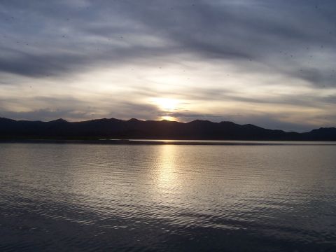 1994 Ford F-150 - A scenic view of a lake and mountains during sunset, with a watermark at the bottom right.